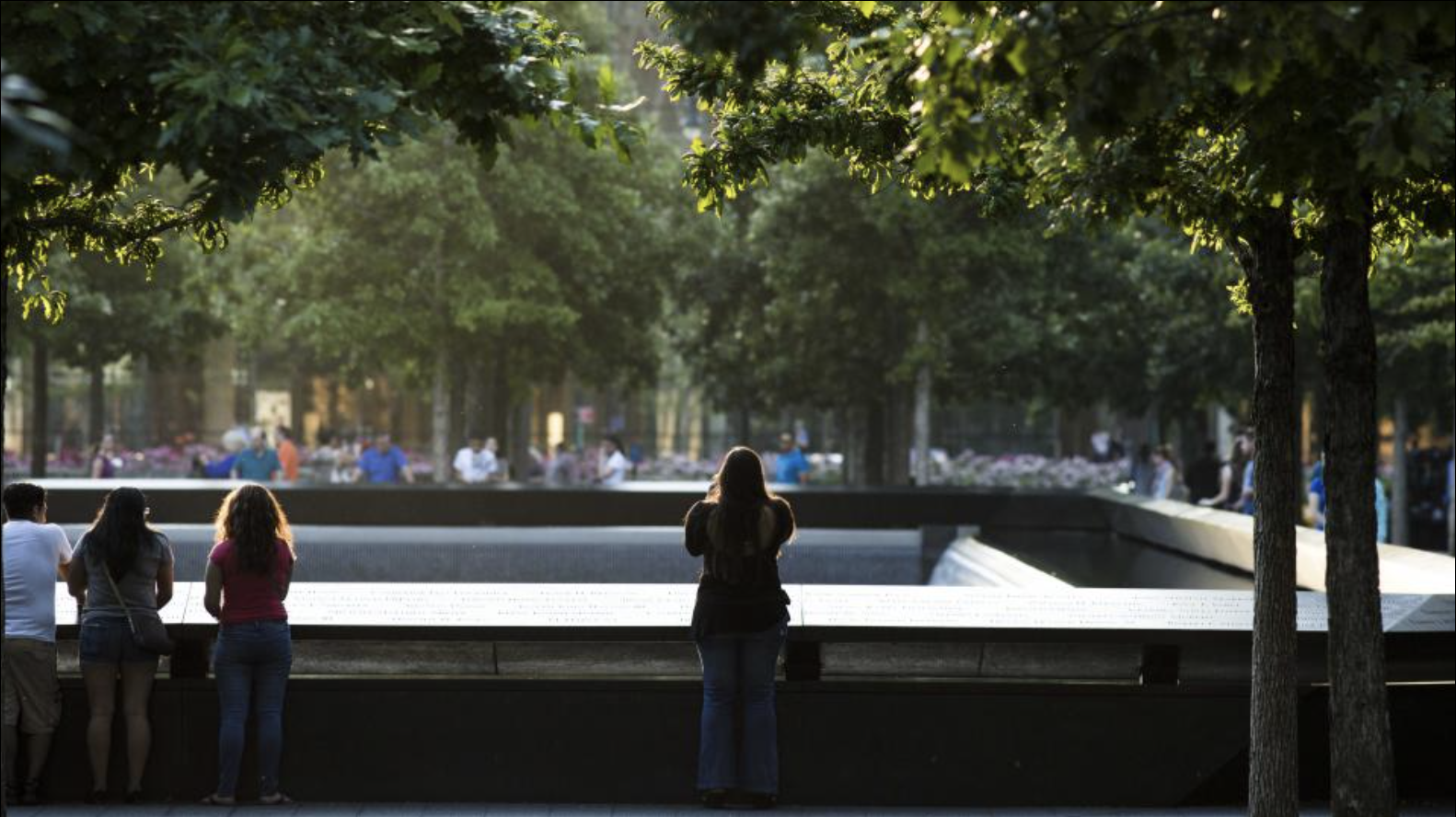 People standing at the edge of the 9/11 memorial