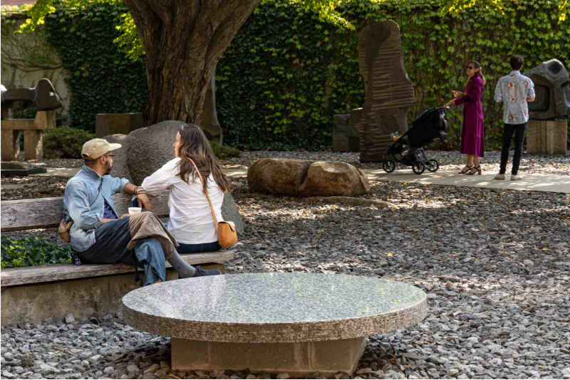 people sitting on a bench in the noguchi museum courtyard