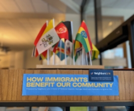 Immigrants benefit our community sign with flags