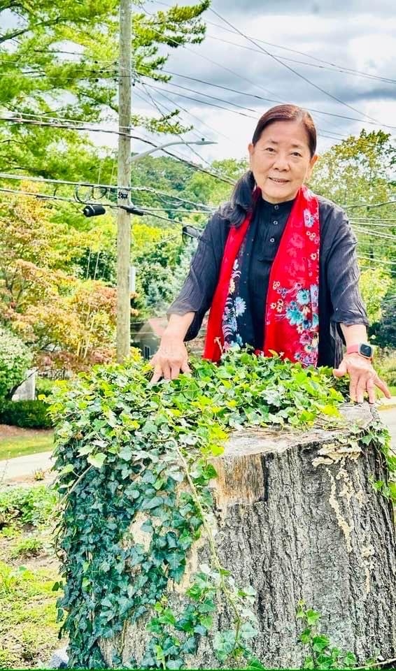 Woman standing behind tree stump